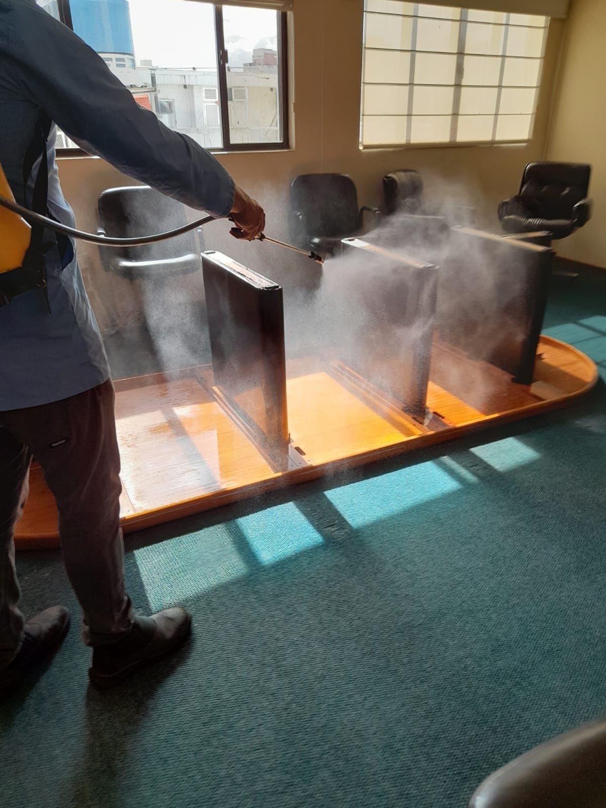 Profissional da C.A TEC Ambiental aplicando controle técnico de pragas em ambiente interno com névoa